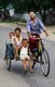 Burma / Myanmar: Three Bamar children riding a bicycle rickshaw, the driver's face protected by thanaka powder